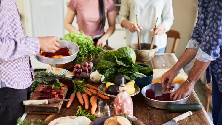 Friends preparing and cooking vegan food.